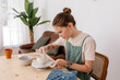 © Tania Cervian/Stocksy - Busy craftswoman modeling clay in creative workroom