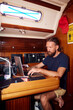 © Boris Jovanovic/Stocksy - Man works on a laptop in boat's cabin