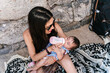 © Ezequiel Giménez/Stocksy - Baby Bottle Feeding on the Beach