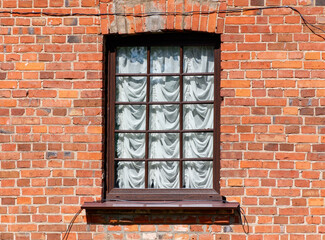 A window with white curtains and a wooden frame