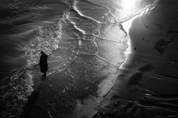 A person is walking on the beach at sunset