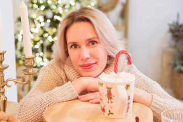 Woman sitting on couch drinking and enjoying, being in dreamy and relaxed mood