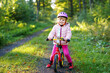 © Irina Schmidt - Child riding balance bike. Kids on bicycle in sunny forest. Little girl enjoying to ride glider bike on warm day. Preschooler learning to balance on run bicycle in safe helmet. Sport activity