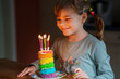 © Irina Schmidt - Happy little preschool girl celebrating birthday. Cute smiling child with homemade rainbow cake, indoor. Happy healthy toddler blowing six candles on cake.