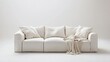 © Pannin - Sleek white sofa with minimalist design, paired with a single throw blanket, centered in a clean white studio. Highlighting simple and modern living spaces.