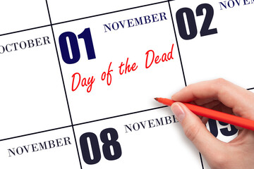 November 1. Hand writing text Day of the Dead on calendar date. Save the date.