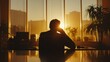 © Prapan - silhouette of an executive sitting at a sleek modern desk,