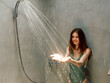 © SHOTPRIME STUDIO - Refreshing shower on a summer day woman standing under running water with hands up in the air