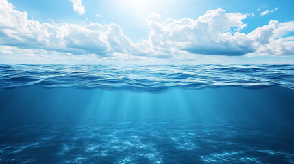 Wall Mural - blue sea or ocean water surface and underwater with sunny and cloudy sky: a split view featuring the