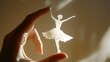 © ChrisTYCat - Delicate Paper Cut Ballerina Figurine Gently Lifted by Hand with Soft Lighting