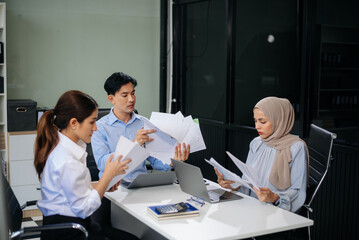 Office colleagues have a casual discussion. During a meeting in a conference room, a group of business teem