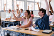 © Xavier Lorenzo - Group of high school students raising hands to answer a question in classroom. Education concept.