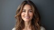 © CinimaticWorks - radiant middle-aged woman with a beautiful smile, looking directly into the camera, gray background setting, confident and serene mood, modern portrait showcasing mature charm and elegance