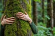 © Сергей Косилко - Nature lover hugging a tree trunk with green moss