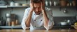 © Yury - Stressed Chef with Intense Headache Struggling in Kitchen