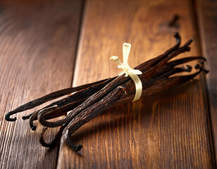 Dried vanilla beans on a wooden table.