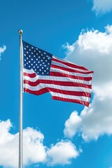 Large American flag waving high in the clear blue sky