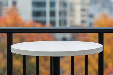 Poster - Empty round white table on a balcony overlooking autumn trees