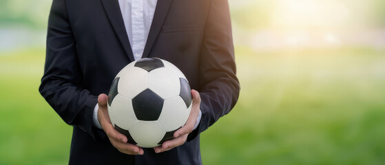 Soccer manager, Soccer ball in hand of businessman Background Blur Football field, Copy space