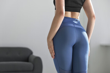 Poster - Woman wearing blue sports leggings indoors, closeup