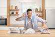 © Ljupco Smokovski - Cheerful young man washing dishes in kitchen