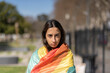 © Mariano - Lesbian girl wrapped in LGBT flag looking seriously at camera