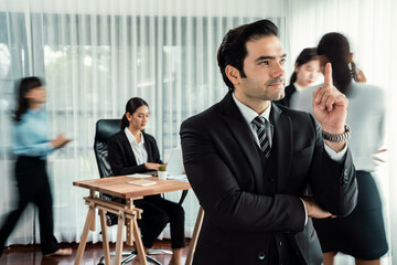 Portrait of happy businessman looking at camera with motion blur background of business people movement in dynamic business meeting. Habiliment