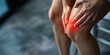 © Denis - Young woman touching hurt knee suffering from joint pain holding with hands red spot. Arthritis or osteoarthritis medical concept.