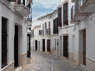 Typical Andalusian stately street in Osuna with white walls with its characteristic bars in Seville