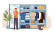 © Natalia - Young man holding hanger with tee shirt at cupboard to find and select garments, organize things. Open wardrobe with clothes, choose stylish outfit for day in closet