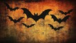 © Umi Sakina - A grunge background with black silhouettes of bats flying across an orange and brown textured backdrop.