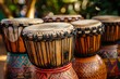 © juliars - Five colorful djembe drums are sitting outside, ready to be played