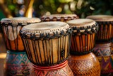 Five colorful djembe drums are sitting outside, ready to be played