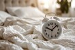 © juliars - White alarm clock is showing seven o'clock on bed after waking up in bedroom in the morning