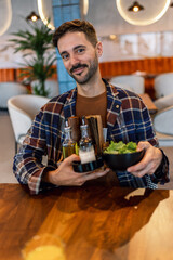 Man in a restaurant holding oil, pepper and napkin holder.