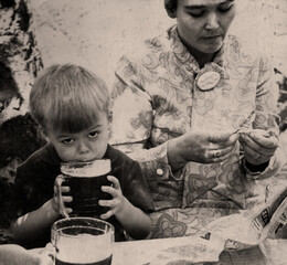 Vintage portrait of a boy with a glass of beer and his mother. Retro photo from 1970