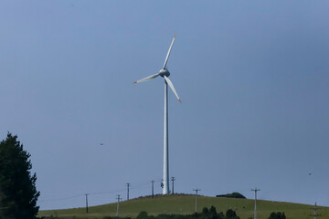 Wind turbine on a cloudless blue sky day. The system of capturing energy from the wind, known as wind power, uses capture towers with three propellers.