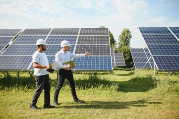 Two engineers or businessmen on the background of solar panels. Renewable energy. Green energy