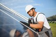 © Serhii - Indian man in uniform on solar farm. Competent energy engineer controlling work of photovoltaic cells
