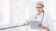 © InsideCreativeHouse - Adult asian female healthcare worker in hospital hallway with clipboard medical report