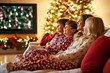 © Gorka Vega Barbero - Family in Christmas pajamas watching holiday movies together