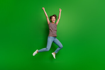 Poster - Full length portrait of delighted carefree person jumping raise fists achievement empty space isolated on green color background