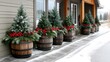 © Viktoriia Kan - Four beautifully arranged Christmas planters featuring wooden barrels filled with pine trees, pine cones, and red berries create a festive outdoor display during winter.