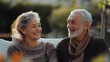 © Aziz - Happy senior couple sitting together outdoors, smiling at each other.