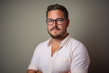 Portrait of a handsome young man wearing glasses and a white shirt.