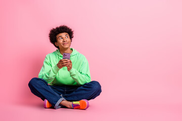 Poster - Full size photo of nice young man phone look empty space wear green hoodie isolated on pink color background