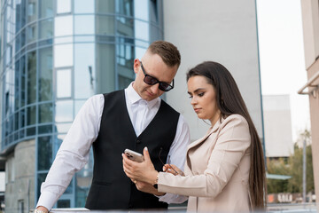 Professional Business Duo Engaged in Collaborative Discussion Outside a Corporate Building