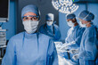 © InsideCreativeHouse - Portrait of female surgeon wearing scrubs and protective glasses in hospital operating theater.