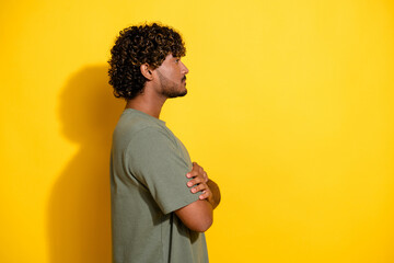 Sticker - Side profile photo of serious cool guy with wavy hair dressed khaki t-shirt look at offer empty space isolated on yellow color background