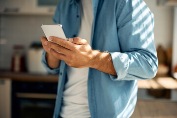 Wall Mural - Close up of man using smart phone at home.